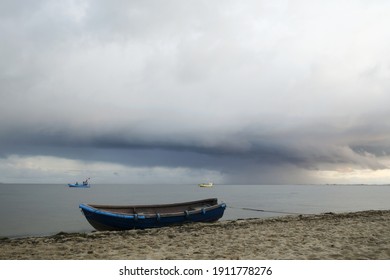 A Boat On A Coast Against A Stormy Sky And Boats In The Water