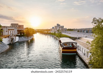 Boat on the pier at water channel Samarkand Eternal city Boqiy Shahar Registan complex at sunset sky background.