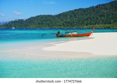 Boat on tropical sea coast with white sandy beach and turquoise water. Summer holiday, travel, beach vacation background