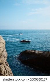 boat with passengers at sea, summer vacation, yacht trip in the middle of rocks and mountains, seascape