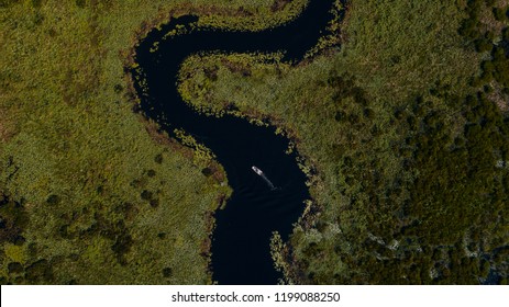 A boat passes through the seemingly  endless Palatlakaha River in Clermont, FL known for its plentiful fishing spots.
