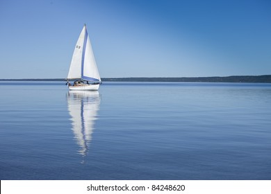 Boat Reflecting In The Water, Sailing In Calm, Blue Water. Swedish Flag On Boat