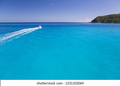 A boat ride across beautiful blue turquoise sea water in Pacific Ocean in a sunny bright daylight blue sky. Seascape of a tropical remote island in the Yasawa Islands group, Fiji.