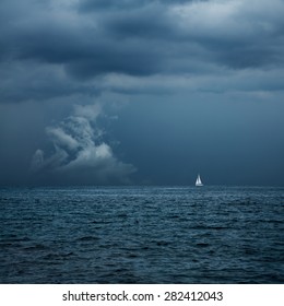 Boat Sailing in Center of Storm Formation. Dramatic Background. Danger in Sea Concept. Toned Photo with Copy Space.