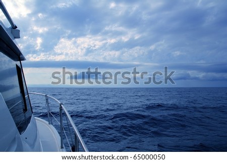 Boat sailing in cloudy stormy day blue ocean sea, yacht side view