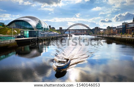 A boat sailing down the River Tyne with Newcastle Tyne Bridge in the distance.