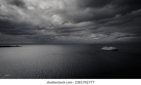 A boat sailing in the open water on a stormy day with grey clouds in the sky