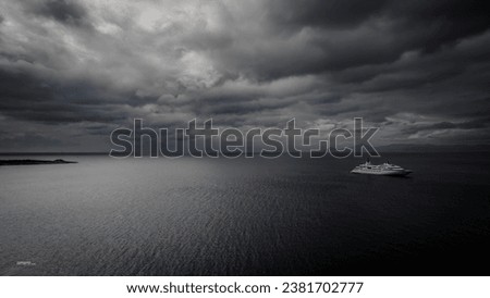 A boat sailing in the open water on a stormy day with grey clouds in the sky