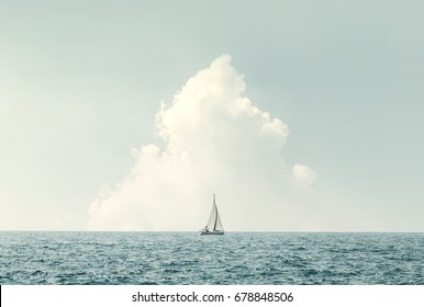 boat sailing in the sea under similar clouds - Powered by Shutterstock