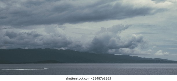 a boat sails under the clouds