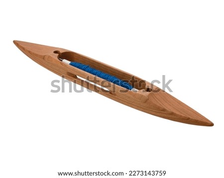 Boat shuttle with blue thread used in loom weaving, isolated. Wooden shuttle on the white background