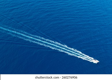 Boat surf foam aerial from prop wash in blue Majorca mediterranean sea