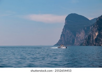 Boat tour with scenic view of lakeside towns on the hills at Garda Lake, Lombardia, North Italy. Surrounded by majestic ridges and cliffs of Garda mountains. Summer lakeside travel destination. Awe - Powered by Shutterstock