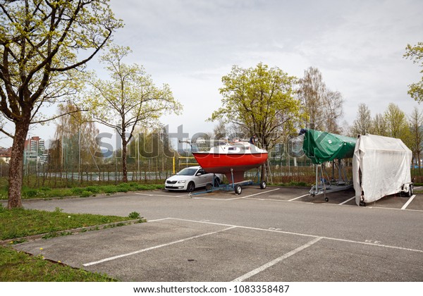 Boat\
trailers covered with tarpaulin in the car parking lot in the town\
of Cham, canton of Zug, Switzerland,\
Europe.