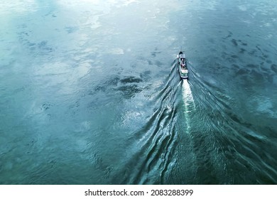 A Boat Or A Tugboat Is Floating On The Water Of The River View From Above. Green Blue Water Beautiful Texture Copy Space