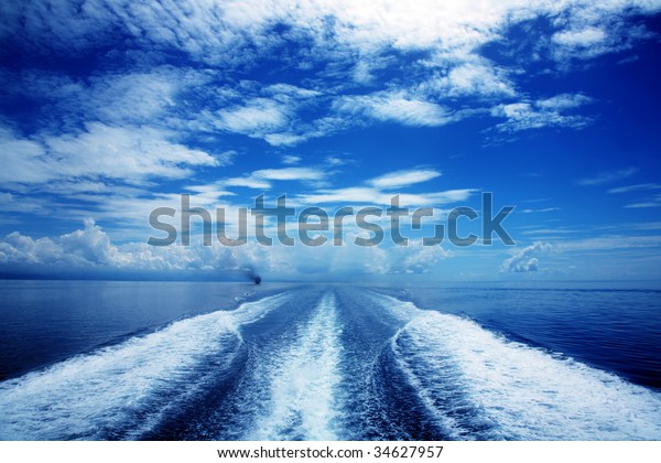 Boat wake in\
the sea, on a brilliant sunny\
day.
