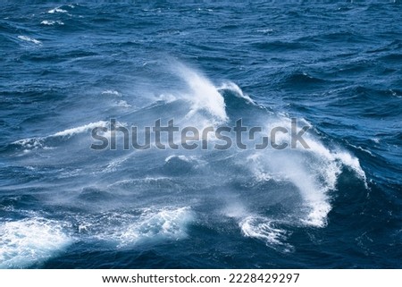 Boat wake waves in the Drake Passage, causing spray to come off   the water. 