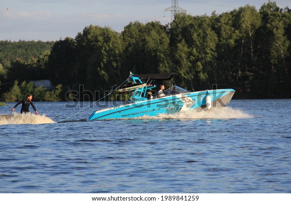 Boat and wakeboarder flies across wake of\
boat. Wakeboarding. Moscow June 3,\
2021