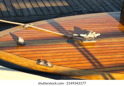 Boat at a wooden dock in harbor. Boat knot equipment. Mooring knot, hitch on wooden desk. Yacht detail. Travel and lifestyle view. Rigging equipment. Varnish wooden desk of boat. Landing stage. - Powered by Shutterstock