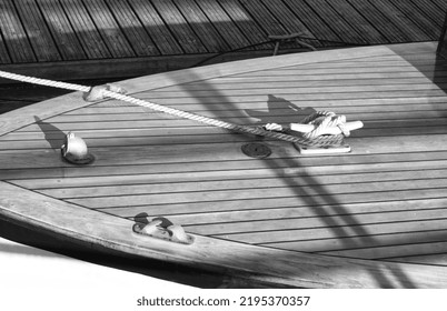 Boat At A Wooden Dock In Harbor. Boat Knot Equipment. Mooring Knot, Hitch On Wooden Desk. Yacht Detail. Travel And Lifestyle. Rigging Equipment. Varnish Wooden Desk Of Boat. Landing Stage. Bw Photo