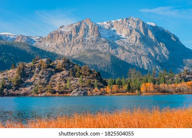 Boaters Hug The Shoreline Of Gull Lake In The Californian Sierra Nevada Mountains In Autumn. 