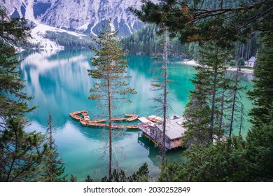 Boathouse and wooden boats at Braies or Pragser Wildsee during sunset pink light. Dolomites, Italy