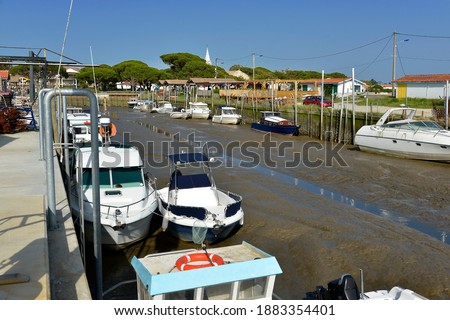 Boats and barge in the ostreicole harbor at low tide of Audenge, commune is a located on the northeast shore of Arcachon Bay in France