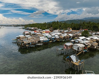 Boats beside stilt houses in Zamboanga raised on stilts. Clear sea water with turquoise water. Mindanao, Philippines.