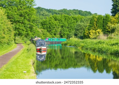 Boats or canal barges moored on the water on the side of the canal in the UK - Powered by Shutterstock