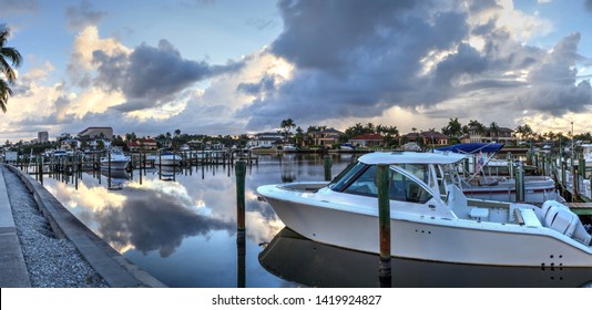 Boats docked at a Marina near Venetian Bay in Naples, Florida at sunrise.