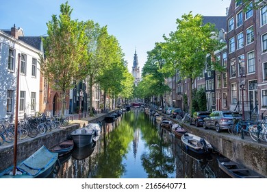 Boats Moored Along The Canal, Amsterdam. Parked Bicycles And Cars On The Street, Traditional  Netherlands Houses, Residential Neighborhood