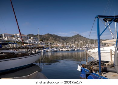  Boats moored in the marina with palm trees, and sitges town in background