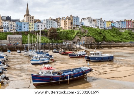 Boats moored in Tenby harbour at low tide in summer, Pembrokeshire Coast National Park in Wales.
