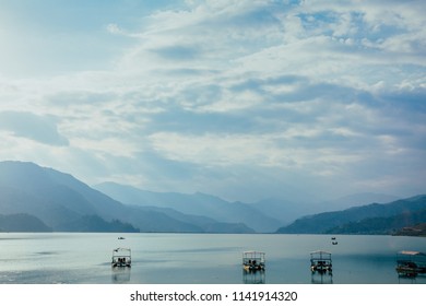Boats on lake under cloudy sky