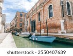 Boats on Venice canal, classic Italian scenery. Historical Venetian houses form red bricks