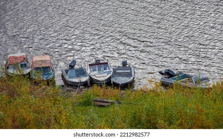 Boats With Outboard Motors On  Traditional Unguarded Parking Lot On River In Siberia. Usual Boat Parking For Motor Boats In The Taiga Village.