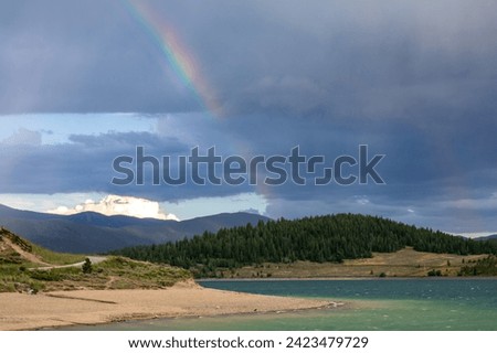 Boats sailing on Lake Dillon in Colorado.  Blue sky, blue choppy water with whitecaps on windblown water.  Waves storm clouds with mountain backdrops.