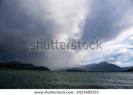 Boats sailing on Lake Dillon I Colorado.  Blue sky, blue choppy water with whitecaps on windblown water.  Waves and sailboats with mountain backdrops.