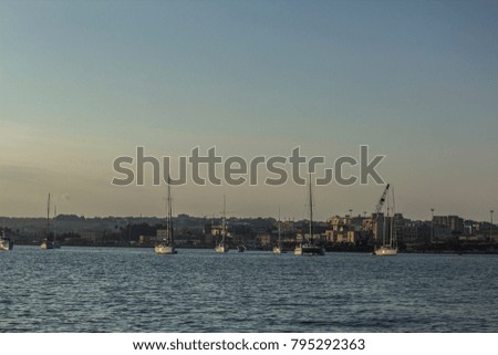 Boats and ships in sunshine and dusk in Siracusa in Sicily, Italy, sea, sun and summer 
