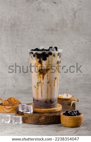 Boba or tapioca pearls is taiwan bubble milk tea in plastic cup with coffee latte flavor on texture  background, summers refreshment.