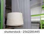 bobbin of white woolen threads in production, weaving machine, cotton mill