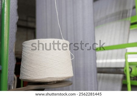 bobbin of white woolen threads in production, weaving machine, cotton mill