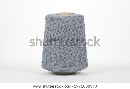 Bobbin of yarn on a white background. Side view. Textile spool on an isolated white background. Close-up.