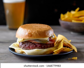 The Bobby Flay Ground Chuck Burger With Ham And Cheese And A Side Of Banana Chips