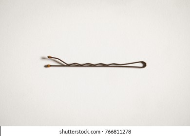 Bobby pin laying on a white background close up