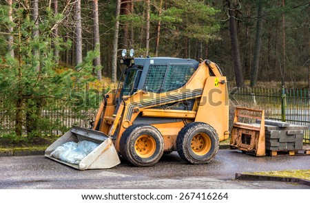 Bobcat or skid loader parked in forest