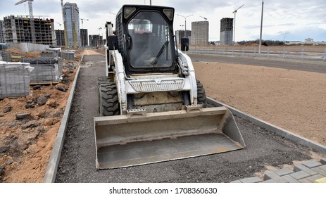 Bobcat Skid-steer Loader For Loading And Unloading Works On City Streets. Сompact Construction Equipment For Work In Limited Conditions. Road Repair At Construction Site.