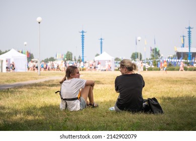 Bobruisk, Belarus July 17, 2021. Mom And Daughter On The Lawn In Front Of The Site Of A Mass Event, Concert.