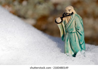 Bodhidharma Figurine In The Snow.  France. 