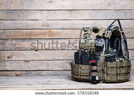 Body armor with ammo and other military equipment on wooden background/Bulletproof vest on wooden table